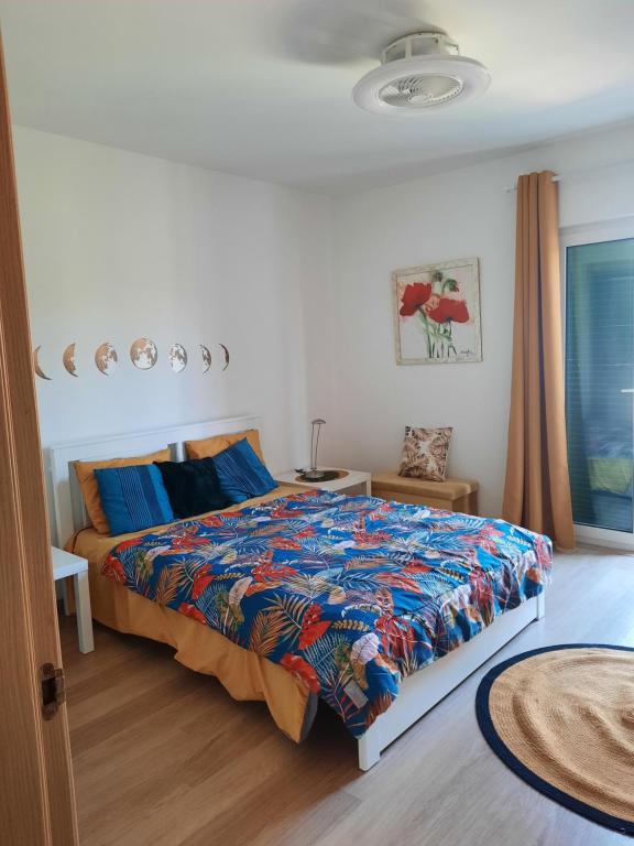 圣玛丽亚vila verde twonhouse T54的一间卧室配有一张带五颜六色棉被的床