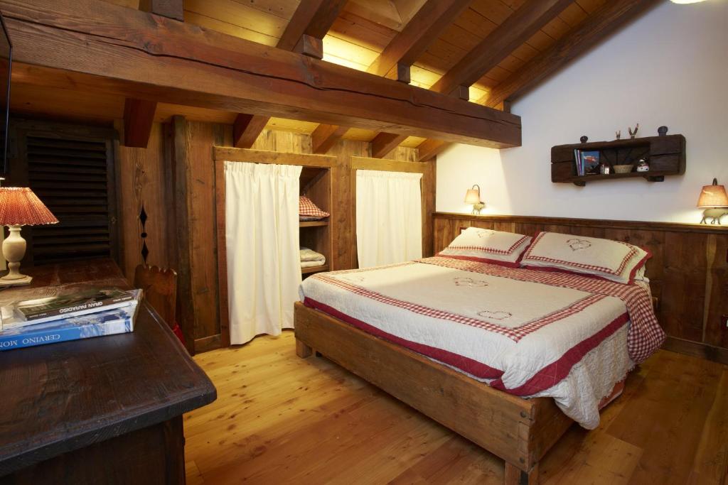 努斯Le Bibelot apartments的铺有木地板的客房内设有一间卧室和一张床。