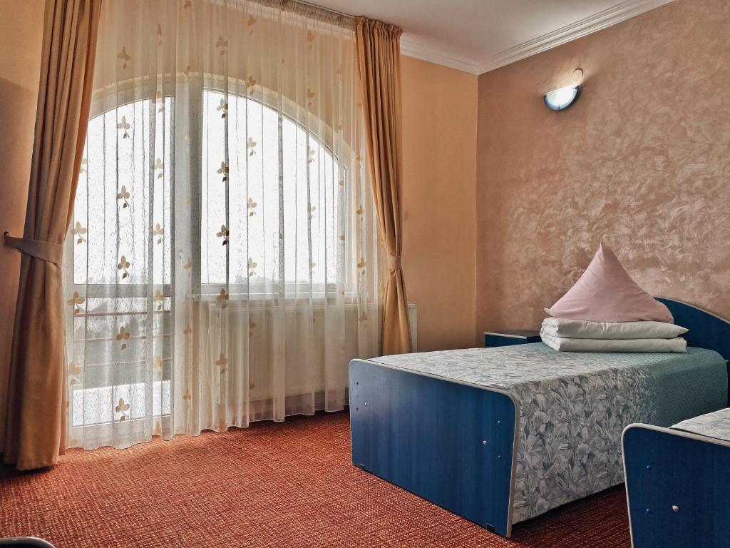 皮亚特拉-尼亚姆茨Hotel Belvedere的一间卧室设有一张床和一个大窗户