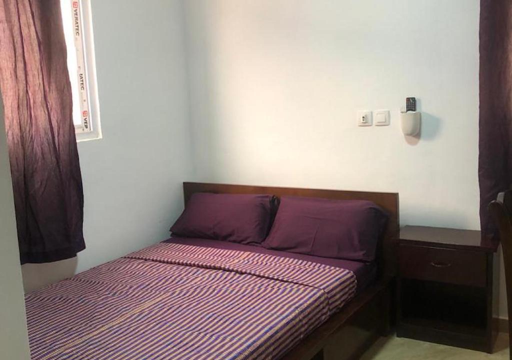 CocodyVilla 34的小房间的小床,配有紫色床单