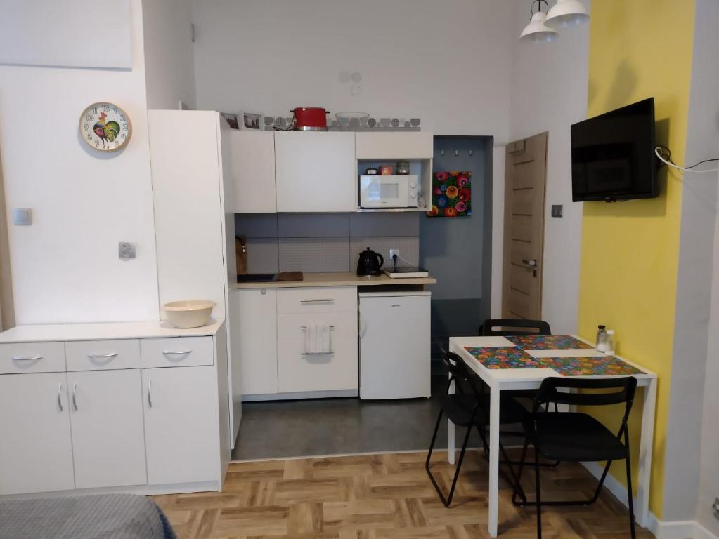 SokołowskoKrokus的厨房配有白色橱柜和桌椅