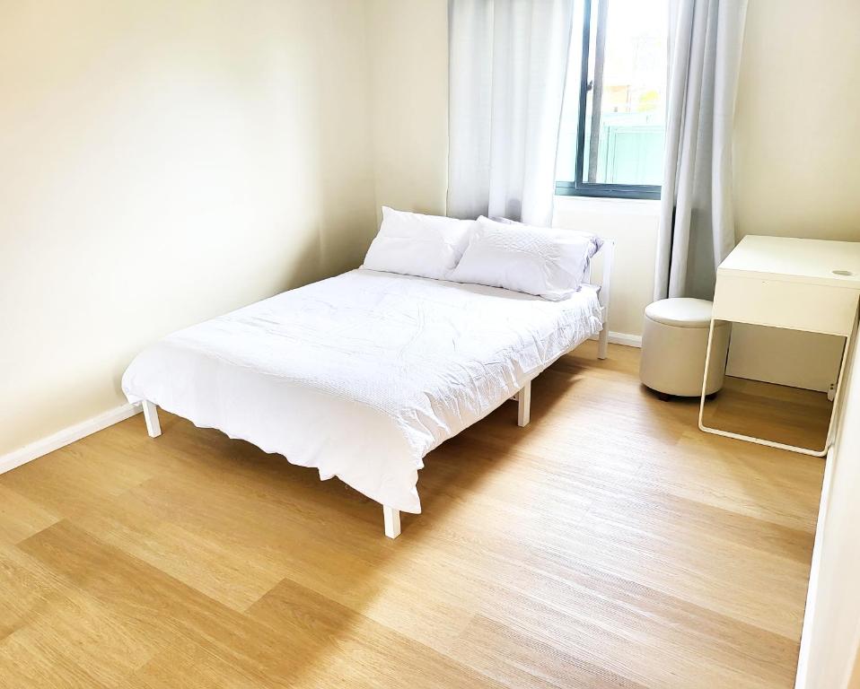 DoonsideKaban Power 7的铺有木地板的客房内的一张白色床