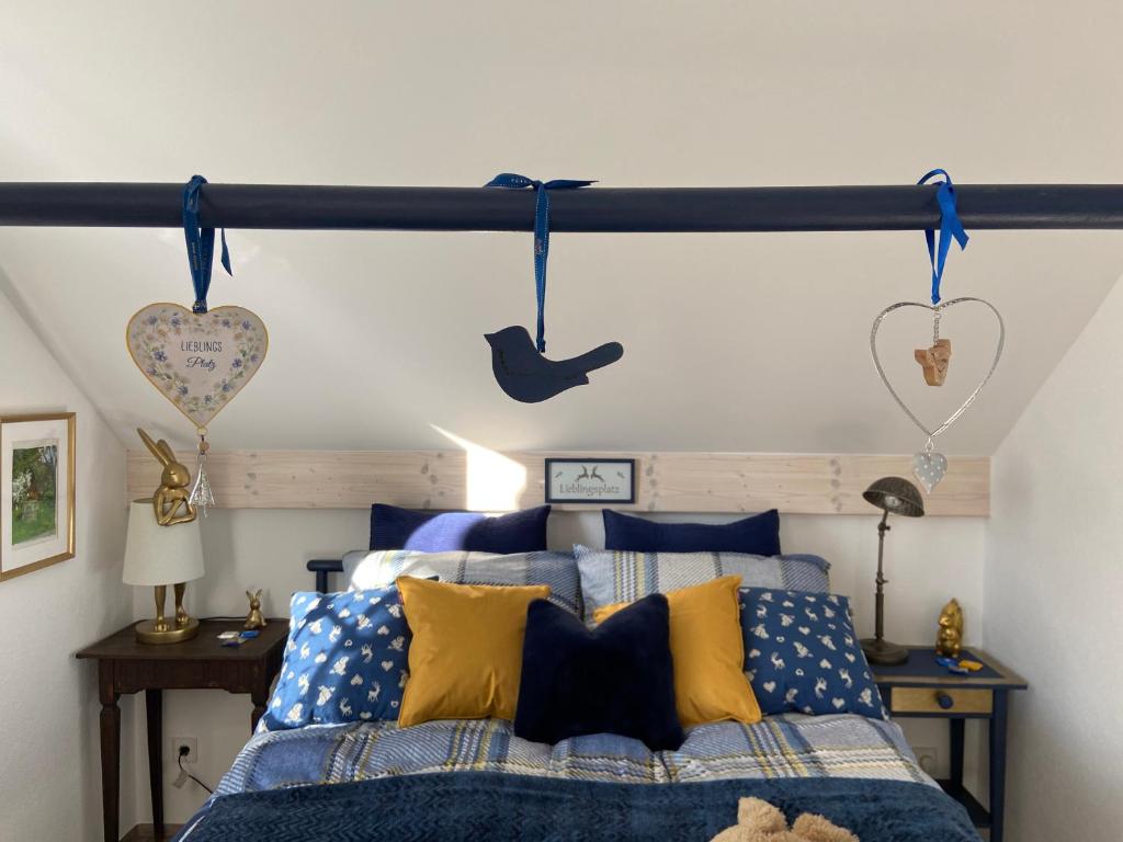 魏勒-锡默贝格Das blaue Haus - ein Sommertraum und ein Wintermärchen的一间卧室配有蓝色和黄色枕头的床