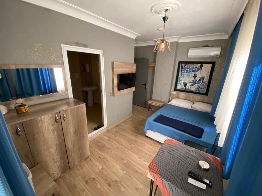 安塔利亚科斯克酒店的小房间设有蓝色的床和一张桌子