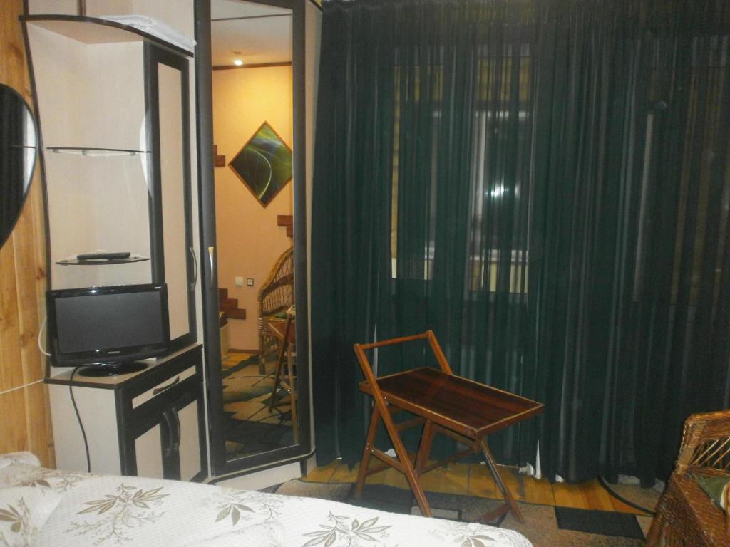 敖德萨奇特科酒店的客厅配有椅子和电视
