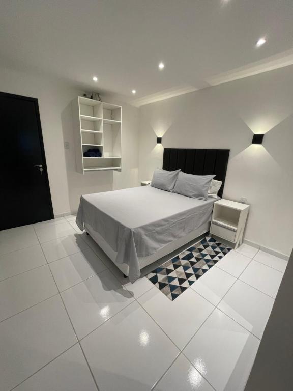 加拉尼温斯Flat Bugayalê的一间白色卧室,配有床和瓷砖地板