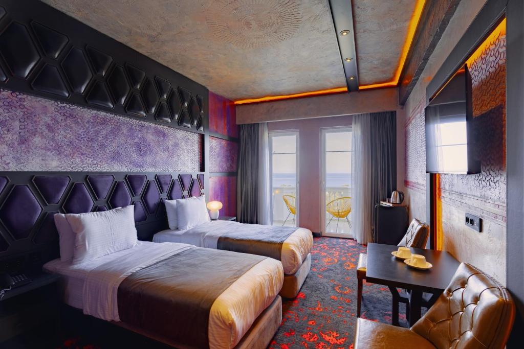 巴统Tapis Rouge Design Boutique Hotel的酒店客房,设有两张床和一张沙发