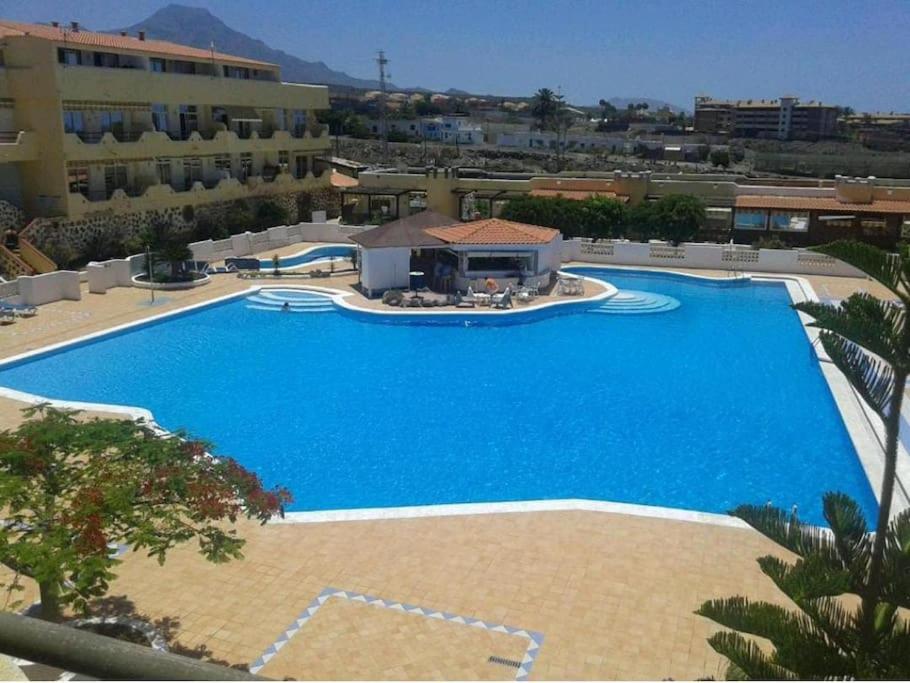 阿德耶Casa de Simo · Sol, Relax y diversión的一座大型蓝色游泳池,位于大楼旁边