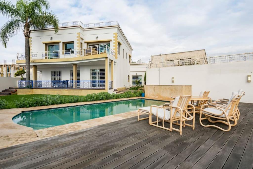 塞拉La villa des corsaires, vue panoramique sur Rabat的一座房子,设有游泳池和甲板上的椅子