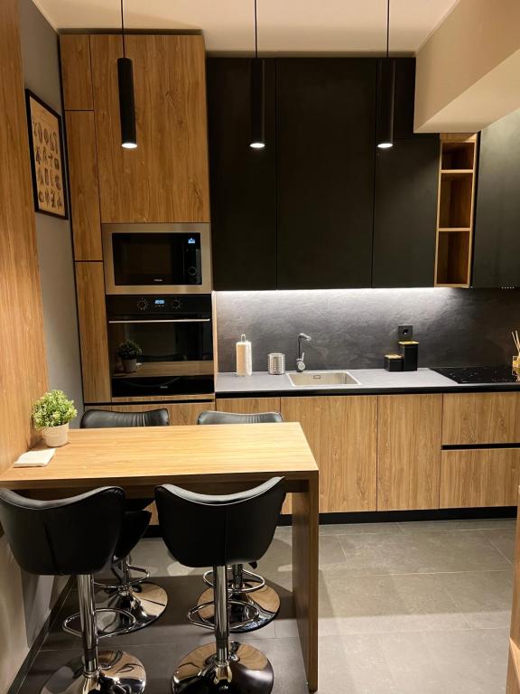 雅西ATH Modern Homes - Luxury Apartment in the City Center的厨房配有木桌和一些黑色橱柜