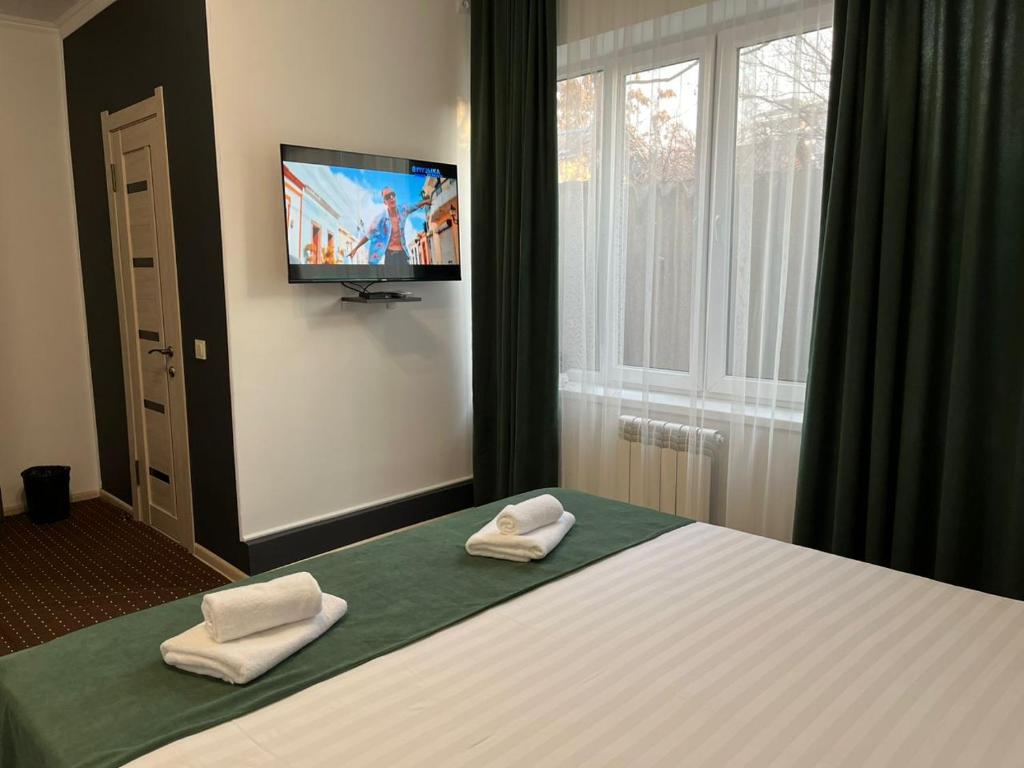 比什凯克A Hotel Bishkek的一间卧室配有一张带两条白色毛巾的床
