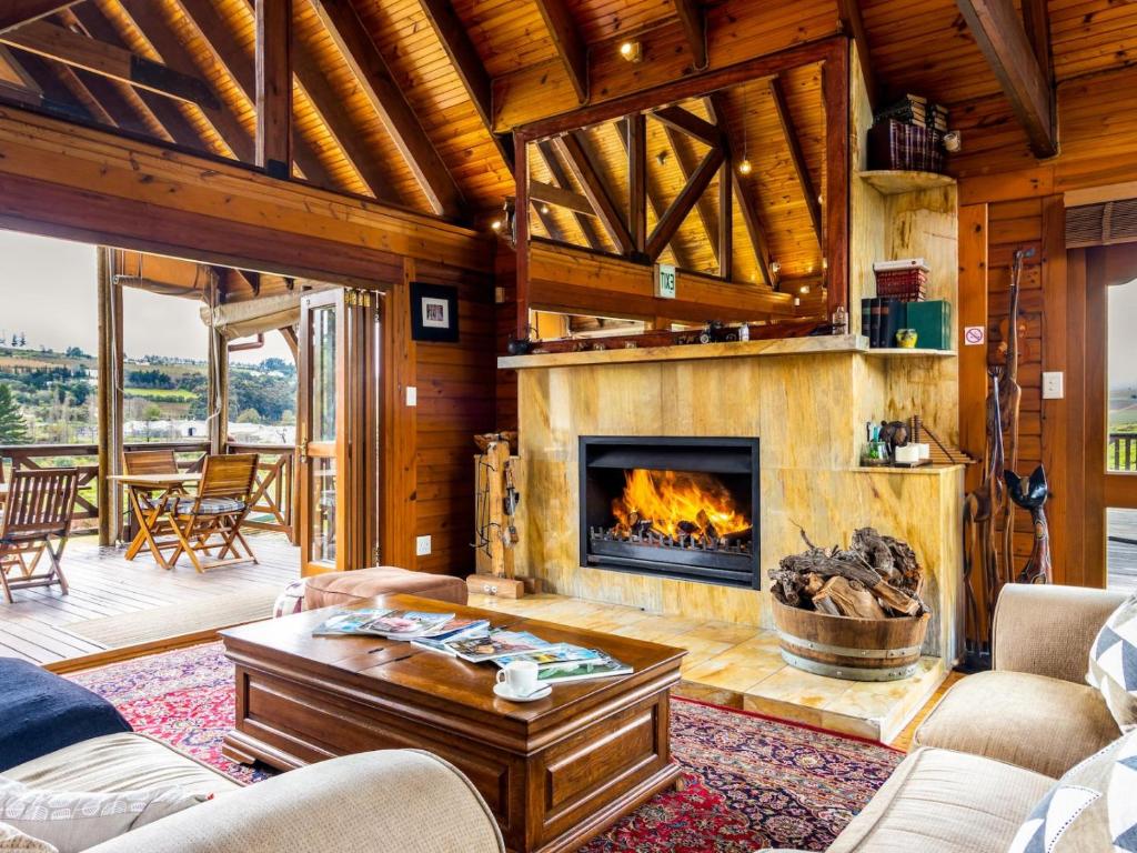 斯泰伦博斯The Log Cabin Lodge的带壁炉的客厅。