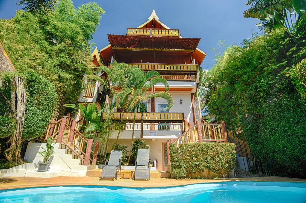 高兰Villa Siam Lanna at Kantiang Bay的房屋前有游泳池的建筑