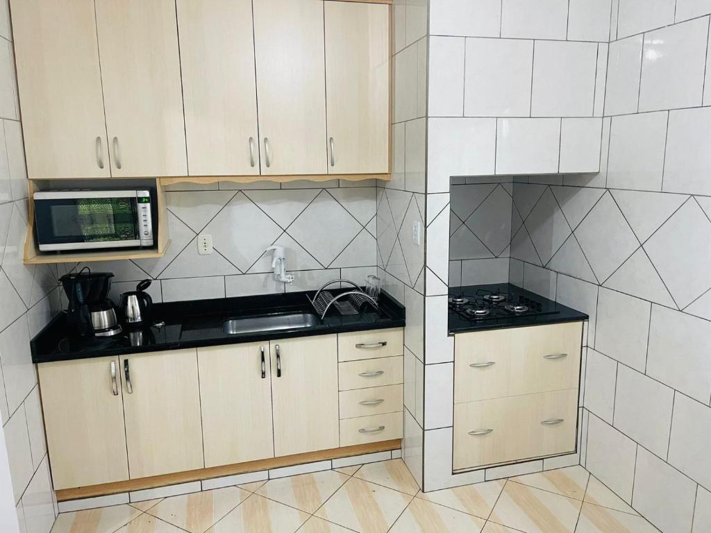 波梅罗迪Suites da Rota - Pomerode SC的一间带水槽和微波炉的小厨房