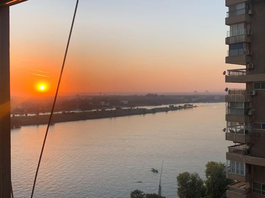 开罗Schöne Wohnung mit Blick auf Nil und Pyramiden的从大楼欣赏日落时的河景