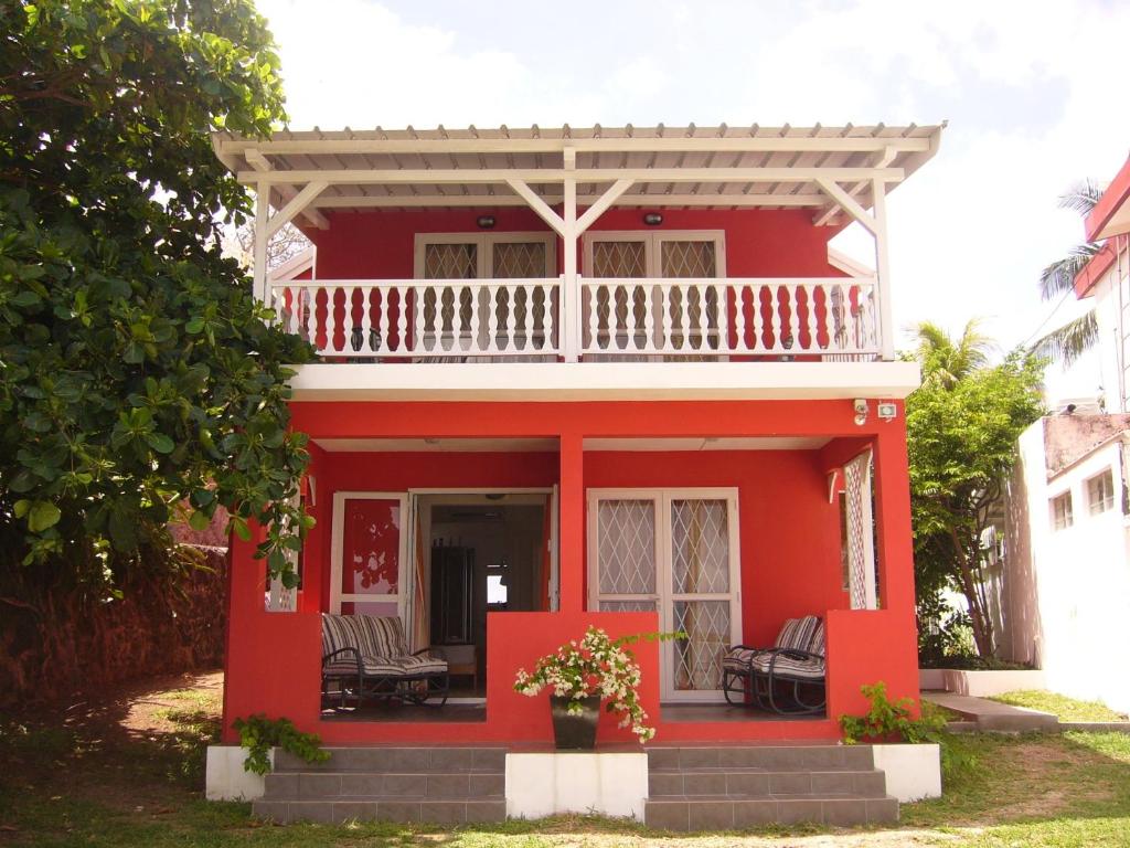 托舵道斯考利博瑞海滩别墅的红色房子,上面设有白色阳台