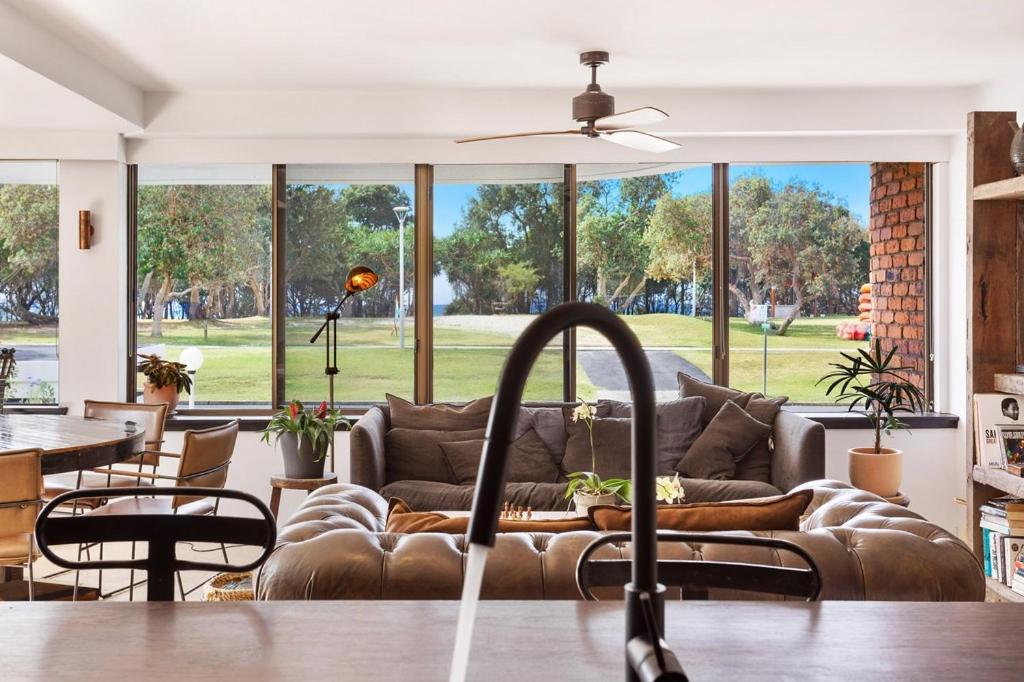 拜伦湾Byron Pacific Apartments - On Clarkes Beach的带沙发和大窗户的客厅
