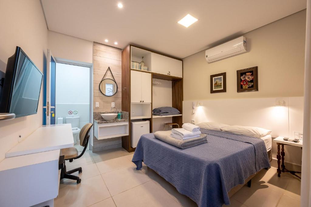 坎皮纳斯K2 Residence的一间卧室配有一张床、一张桌子和一个水槽