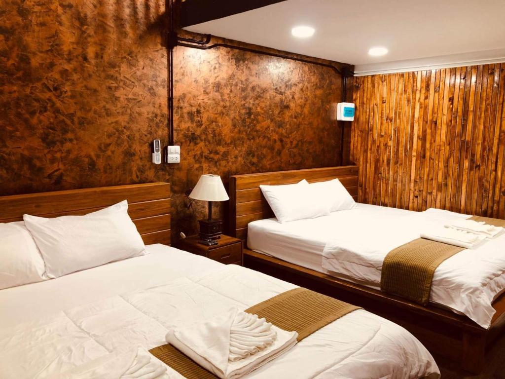 Ban Ton Liangกอบสุข รีสอร์ท2 k13的木墙客房的两张床