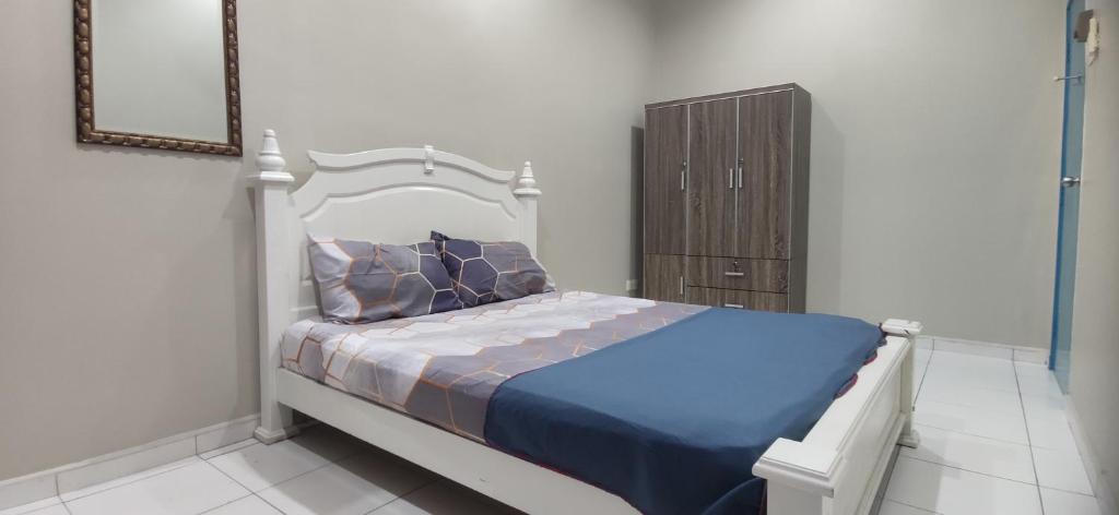 巴特沃思Al Irfan Homestay Tmn SgDua Utama的一间卧室配有一张床和一个木制橱柜