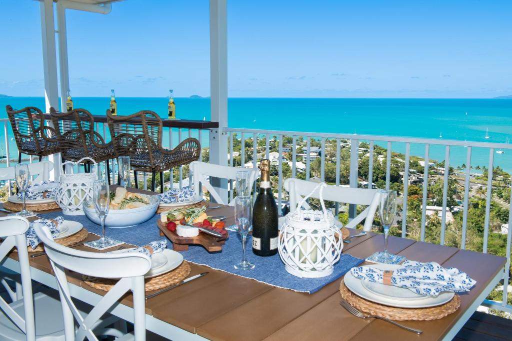 埃尔利海滩South Hamptons Beach House的阳台上的餐桌上摆放着食物和葡萄酒