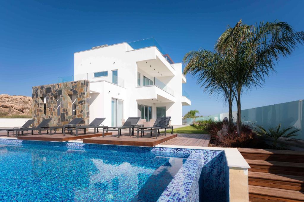 阿依纳帕Sea Pearl Beachfront Villas - Breeze的一座白色的房子,前面设有一个游泳池