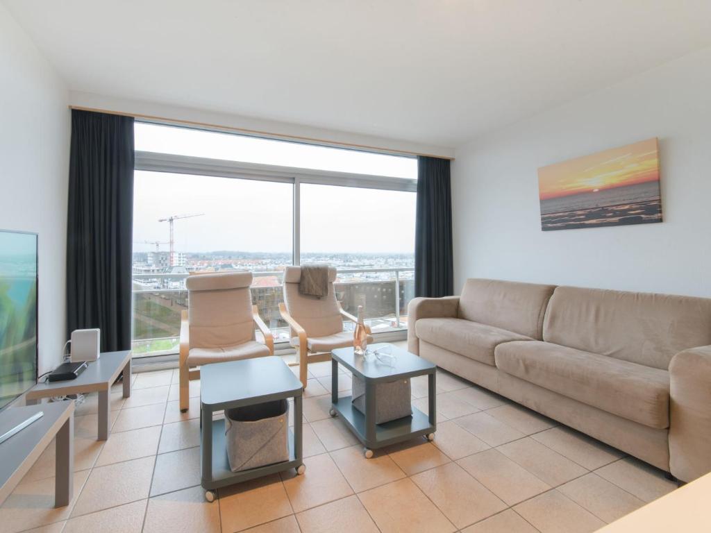 布列登Apartment Residentie Astrid-4 by Interhome的带沙发和椅子的客厅以及大窗户。