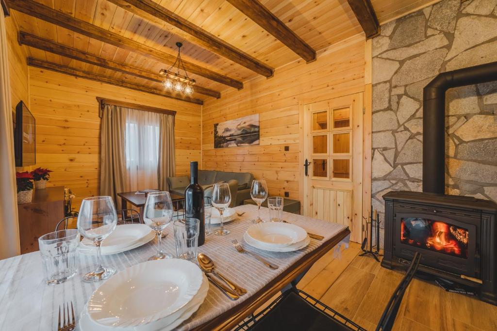 莫伊科瓦茨Eco Village & Chalets Green Heaven的一间带桌子和燃木炉的用餐室