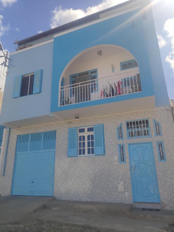 明德卢Maderalzinho的拥有蓝色门和阳台的房子