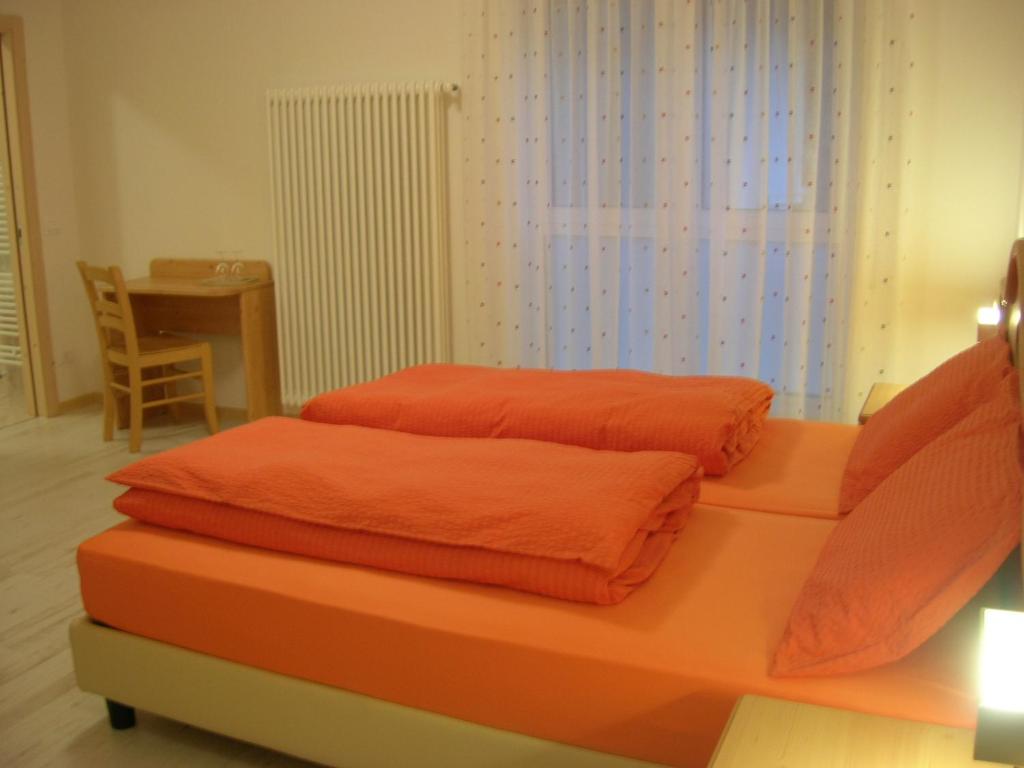 特伦托Agriturismo La Decima的一张床上的橙色床单