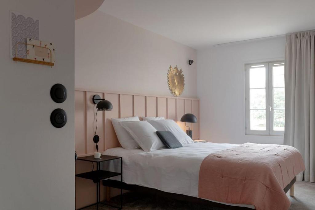 帕雷·勒·毛尼尔Hôtel Le Prieuré的白色的卧室设有一张大床和一个窗户