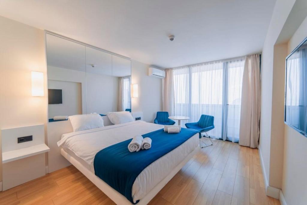 巴统Orbi City Sea View的一间卧室配有一张大床和两张蓝色椅子