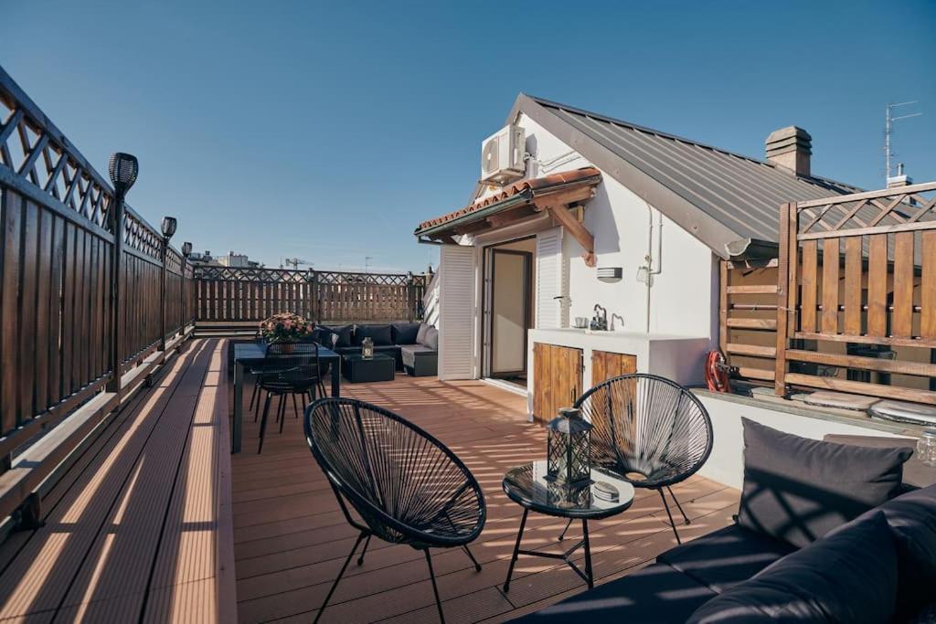 米兰Sant’Andrea Penthouse by Montenapoleone Living的阳台的甲板上配有椅子和沙发
