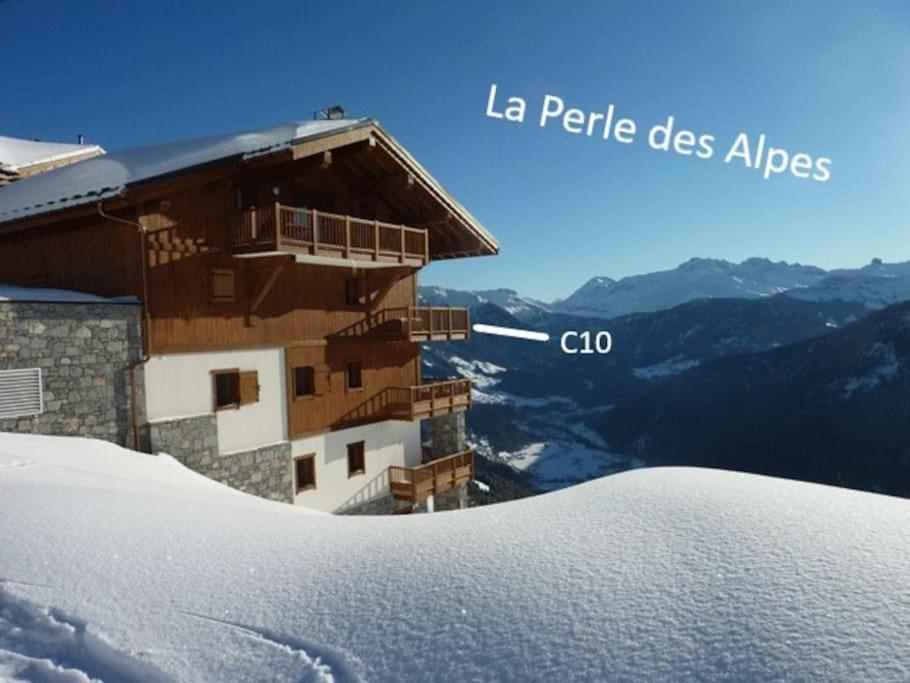 维拉尔叙尔多龙La Perle des Alpes C10 Apart.4* #Yolo Alp Home的一座白雪覆盖的山顶上的建筑