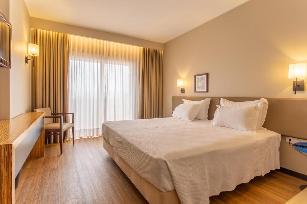 圣玛丽亚大德费拉诺瓦克鲁斯酒店的酒店客房配有一张带白色枕头的大床