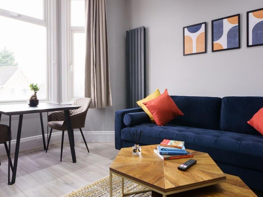 伦敦Modern apartment near Wembley Stadium的客厅配有蓝色的沙发和桌子