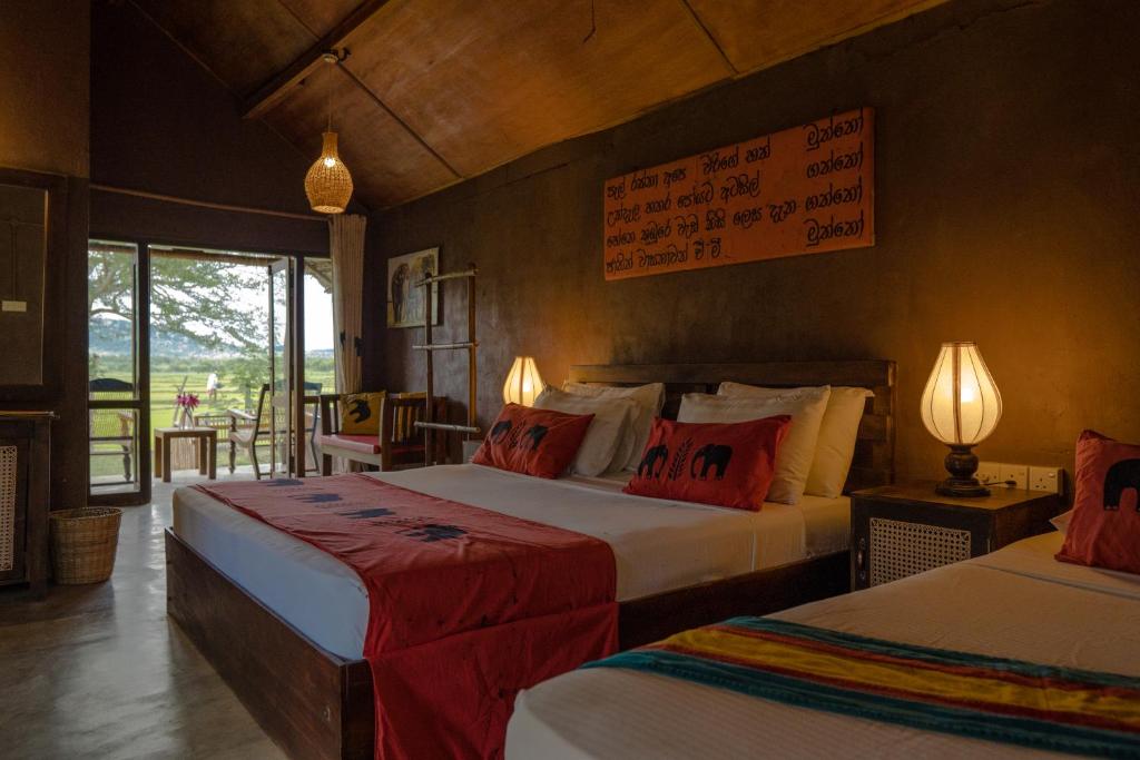 蒂瑟默哈拉默加加蜜蜂雅拉酒店的一间卧室配有两张带红白色枕头的床