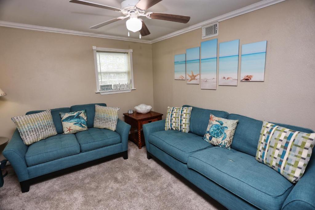 加尔维斯敦Quick & Intimate Beach Getaway的客厅配有2张蓝色沙发和吊扇