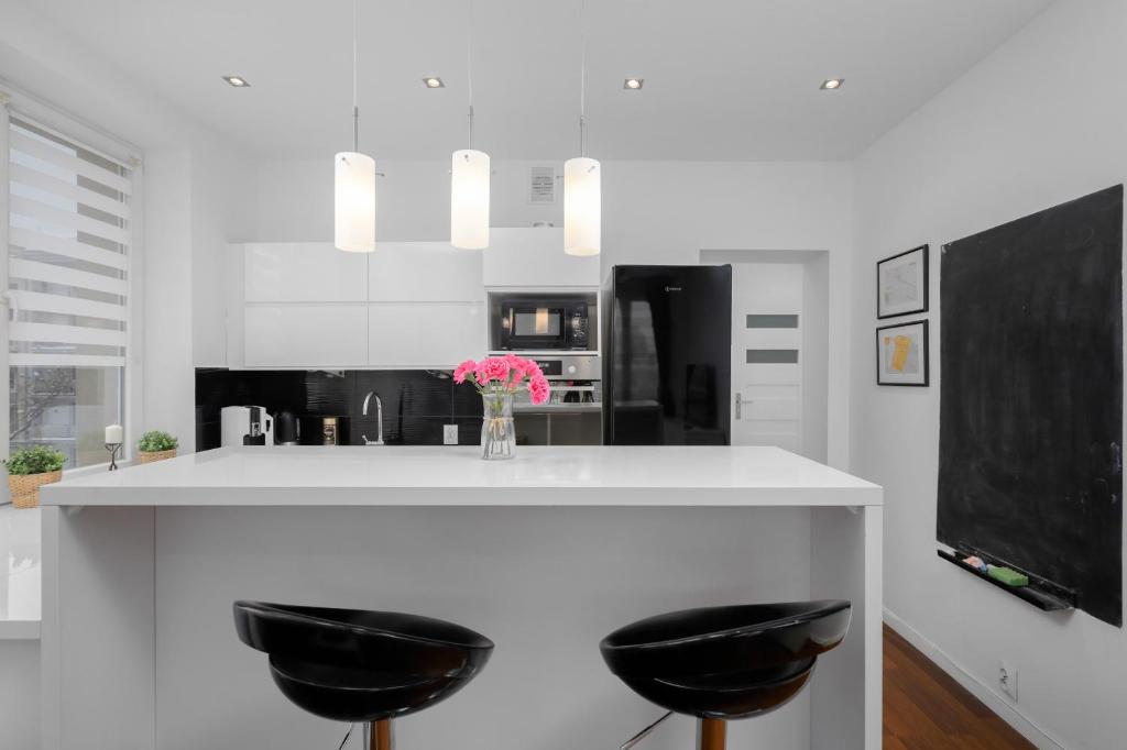 克拉科夫Black&White的厨房配有两个黑色凳子和台面