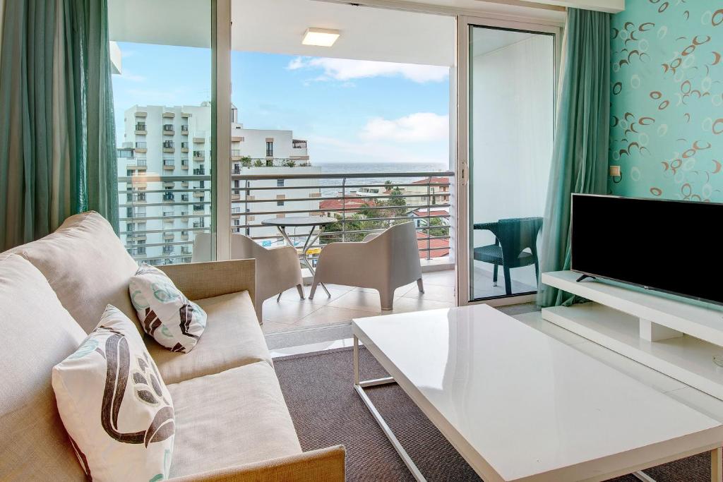 丰沙尔Dfm Happy Days C - Funchal的带沙发和电视的客厅以及阳台。