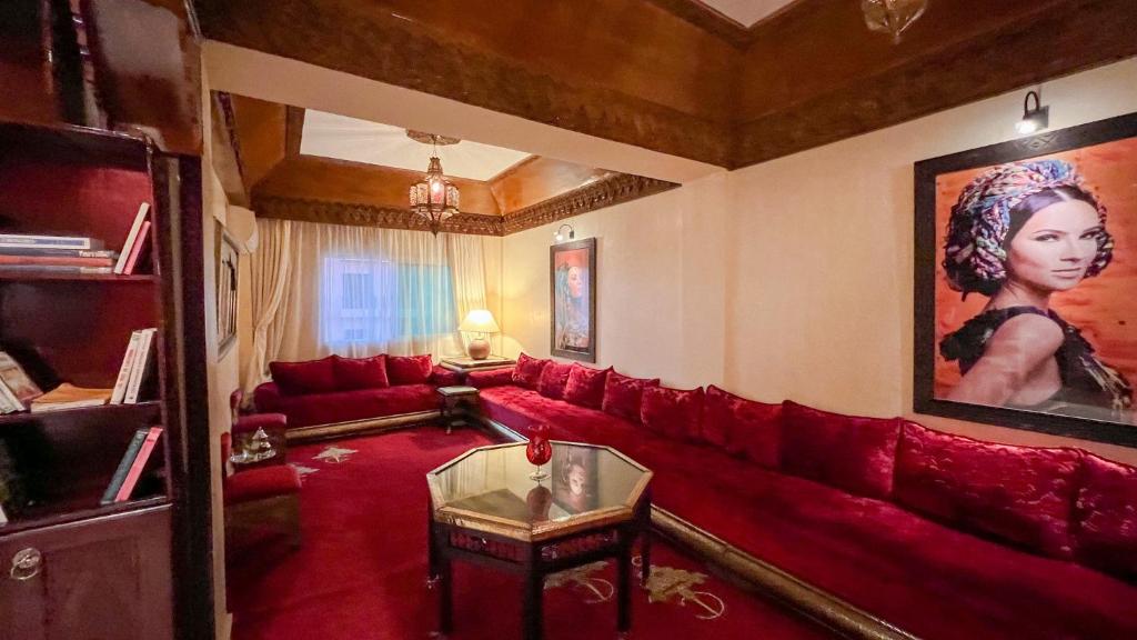 马拉喀什Flair's Family Apartment的客厅配有红色沙发和绘画