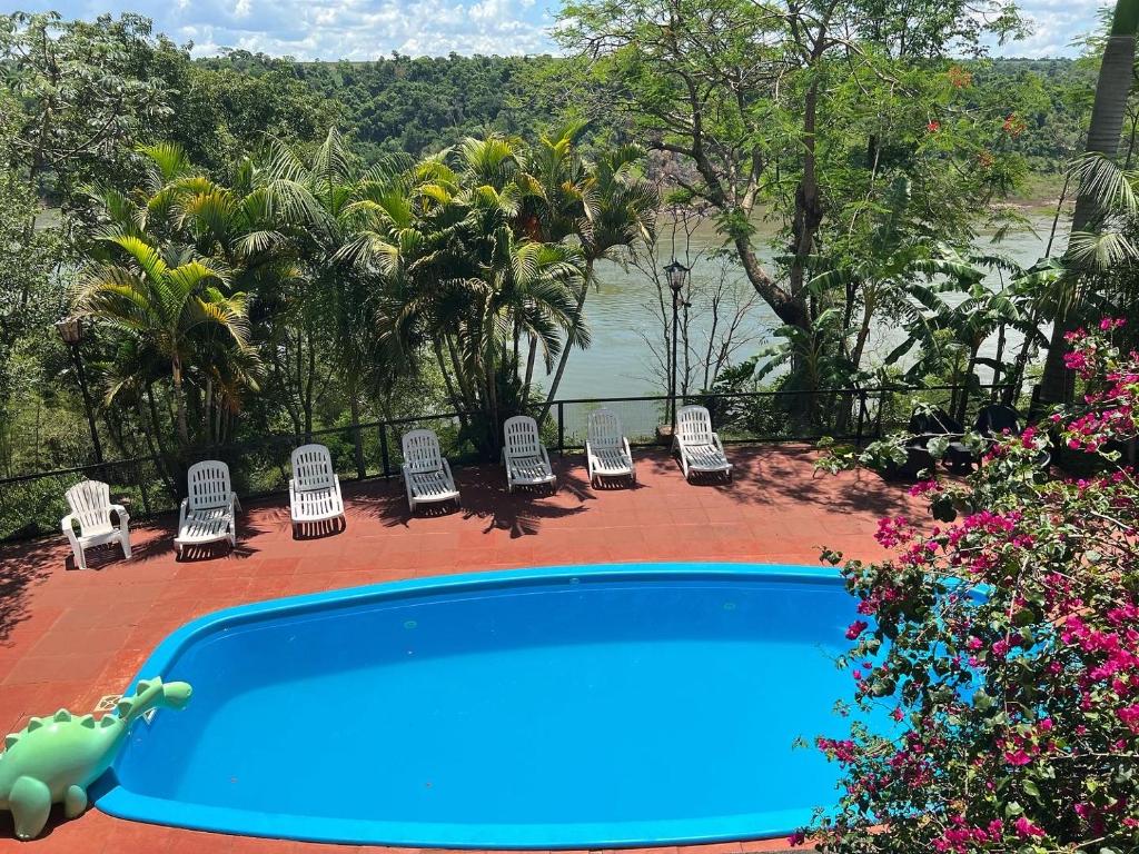 伊瓜苏港太阳海岸伊瓜苏宾馆的一个带椅子的游泳池,享有水景