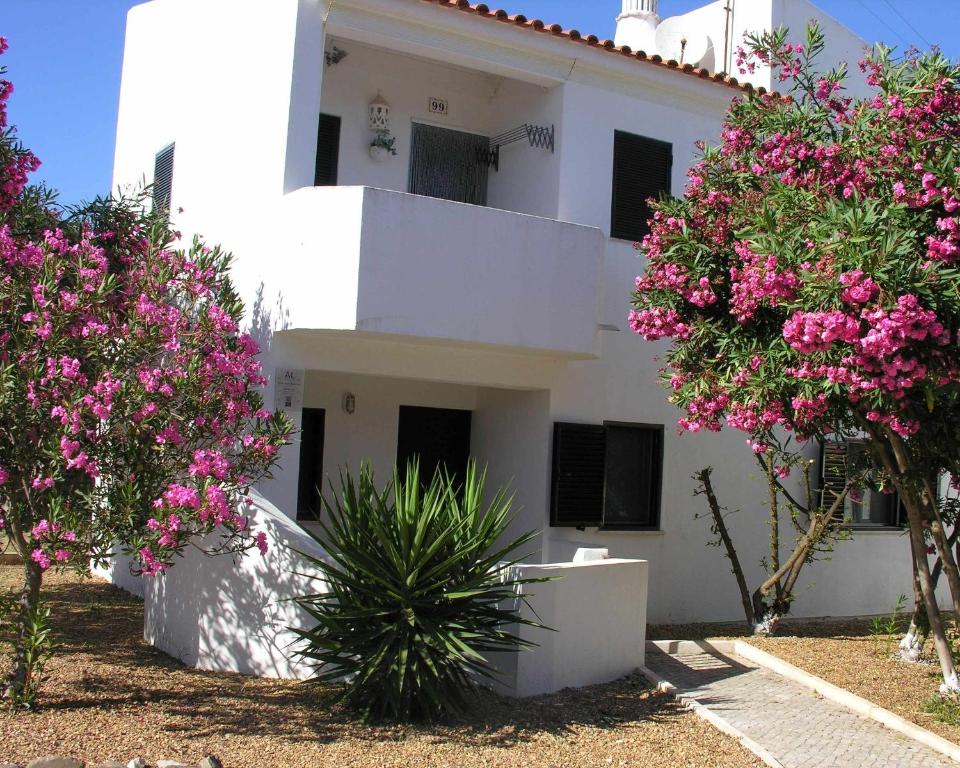 马林堡Retur Algarve Beach House的前面有粉红色花的白色建筑