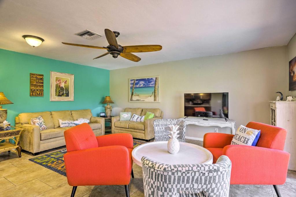 北迈尔斯堡Pet-Friendly Fort Myers Home with Heated Pool!的客厅配有橙色椅子和吊扇