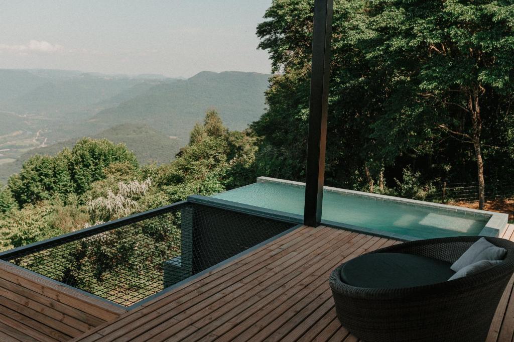 南卡希亚斯Casas na montanha - Villa Montegrappa的阳台设有小型游泳池和甲板上的椅子