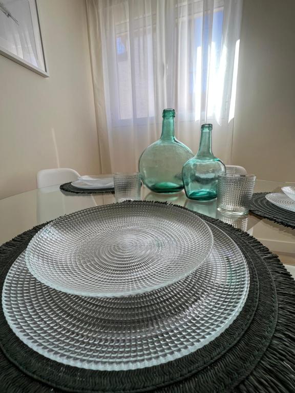 科尔多瓦Apartamento Córboba Centro的一张桌子,上面有两瓶玻璃瓶和一个盘子