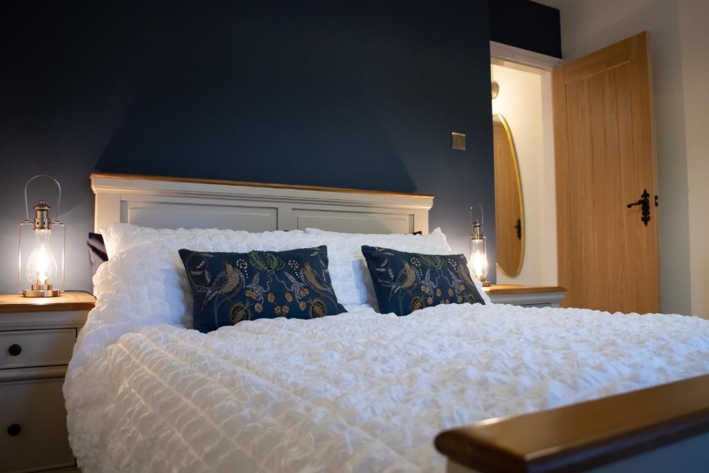 凯尔索The Burrow的卧室配有白色大床和蓝色的墙壁