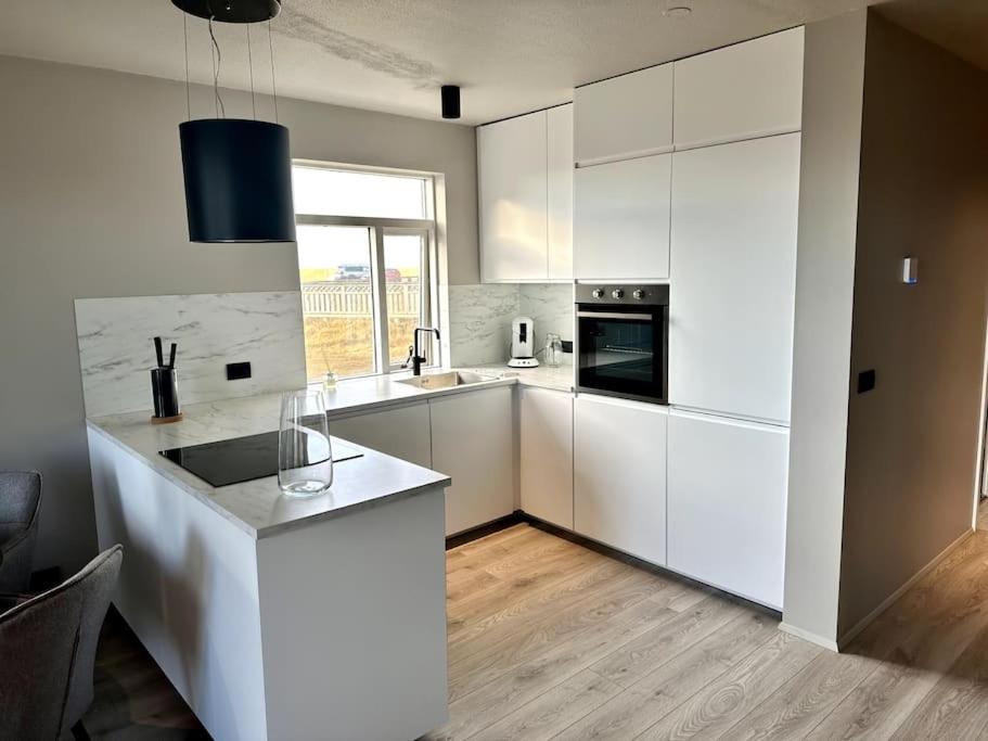 凯夫拉维克Elegant apartment in Keflavík的厨房配有白色橱柜和台面