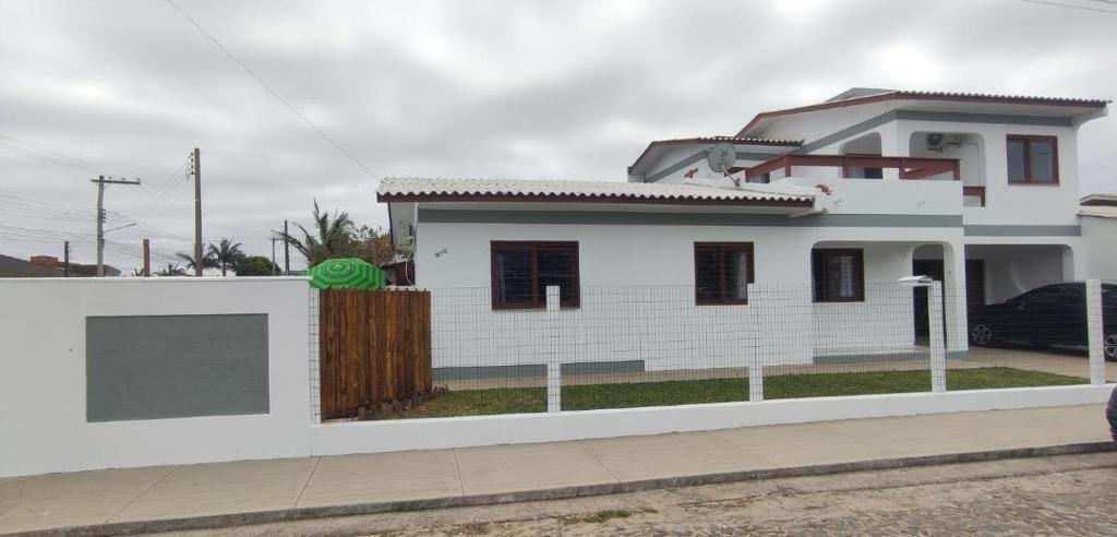 托雷斯Casa ideal para suas férias的前面有栅栏的白色房子