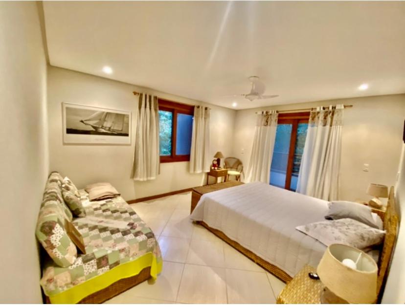 瓜鲁雅Casa elegante em condomínio的一间大卧室,配有一张床和一张沙发